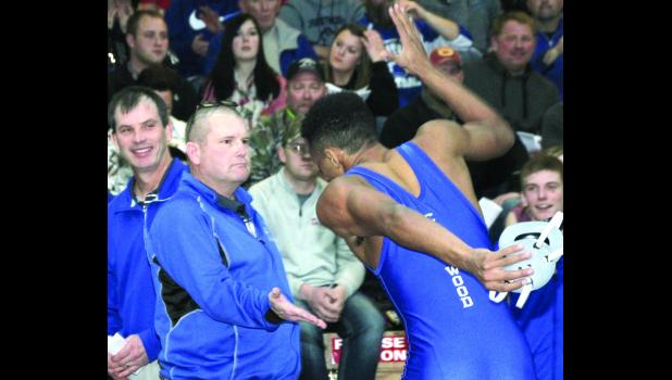 Chris Guest is congratulated by Coach Keith Slifka after Guest defeated Keegan Tenge of New Hampton in the semifinals at 145.