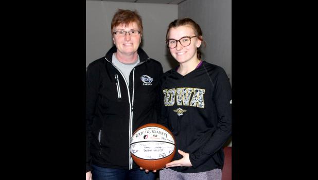 Luann (Balik) Pisney, left, and her daughter, Shelby pose for a photo with a basketball the 2018-19 team was presented after the 2019 State Tournament.