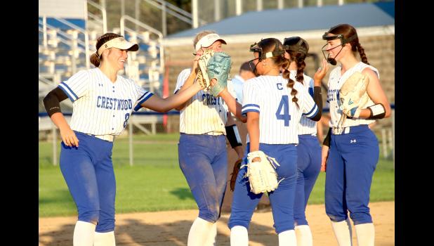 Members of the Cadet softball team give each other high fives during the game against Oelwein on July 9.